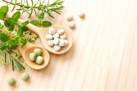 Decorative picture of two wooden spoons in top left corner holding supplements and herbs