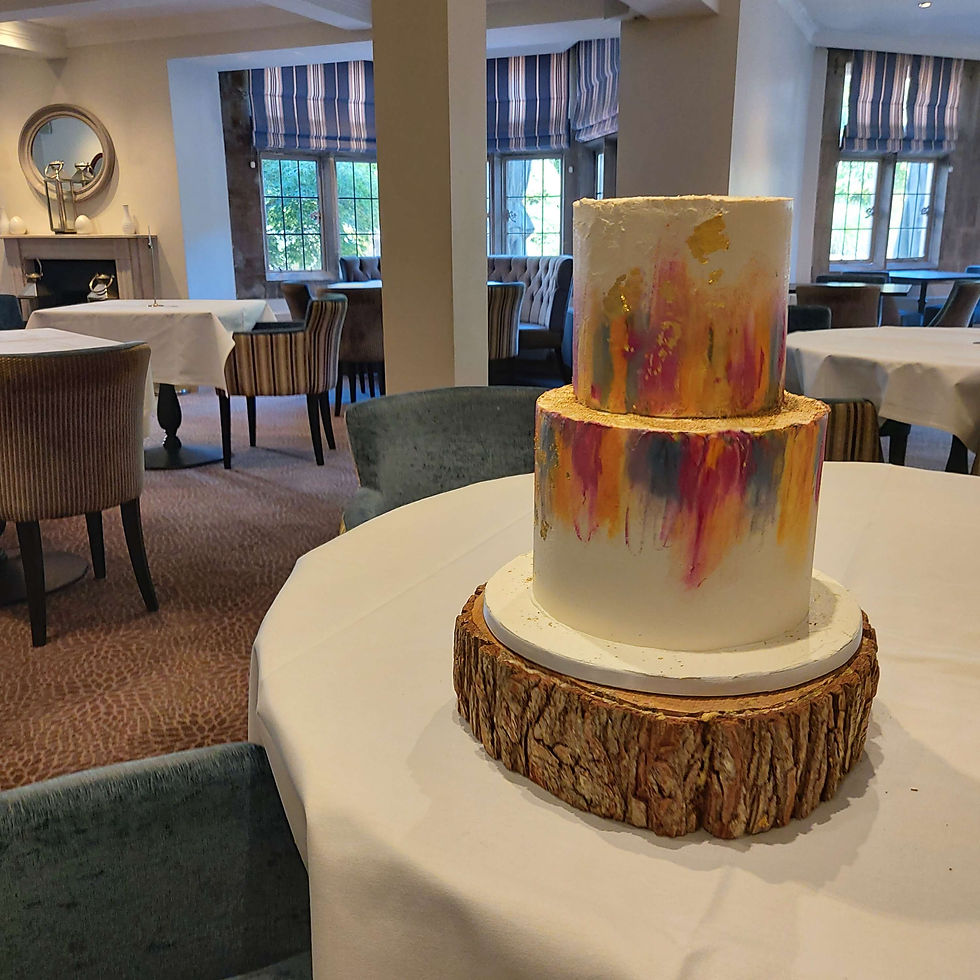 Brigth 2 tier cake with blue, yellows and pink in a modern abstract finish at Burford Bridge Hotel