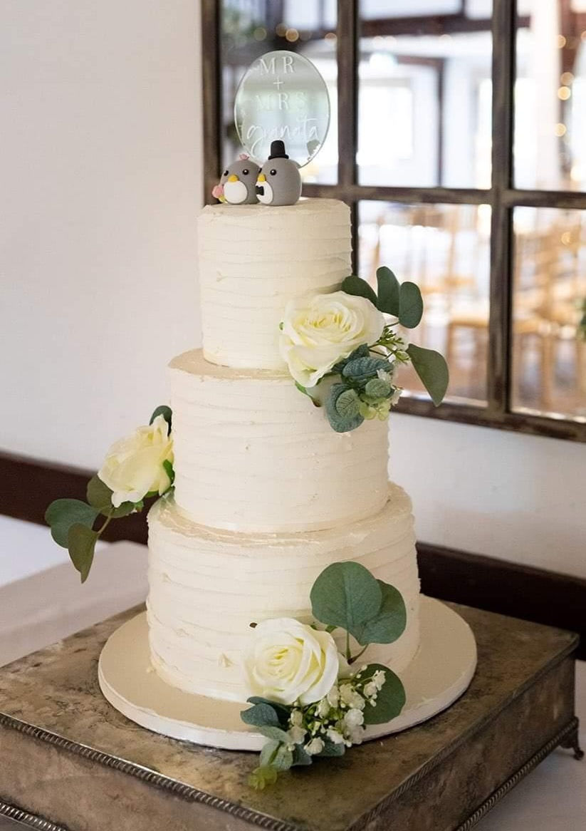 3 tier textured buttercream with faux flowers at Burford Bridge Hotel