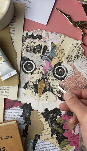 Close-up of handcrafted paper owl with paint, brushes and collage materials.
