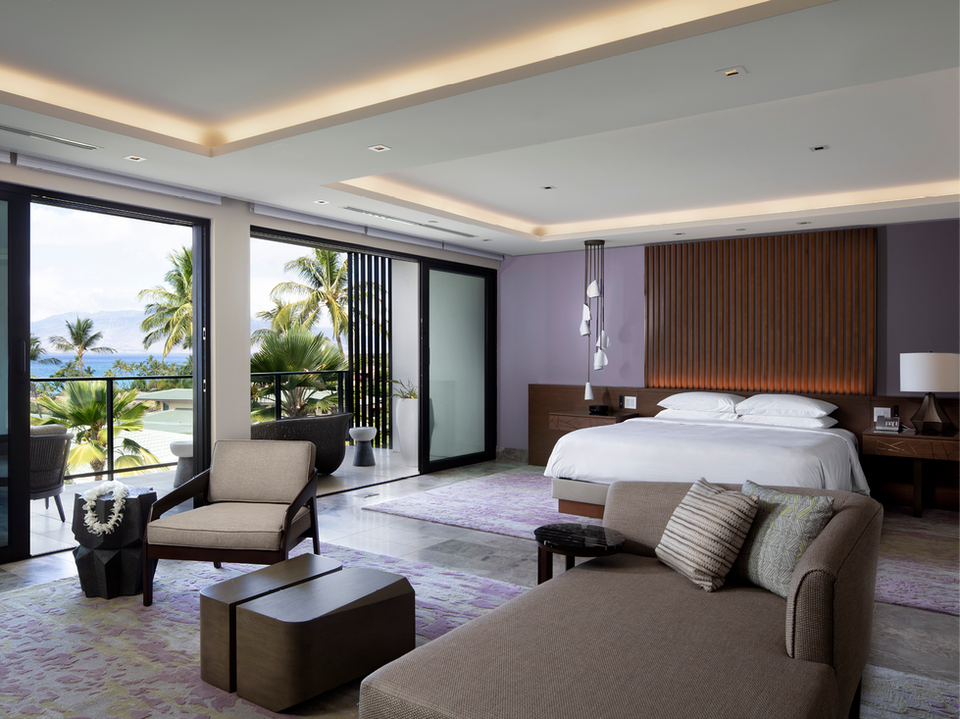 Romantic Oceanfront Bedroom – A sophisticated bedroom with warm wood paneling, elegant lighting, and a glass door leading to an ocean-facing balcony.