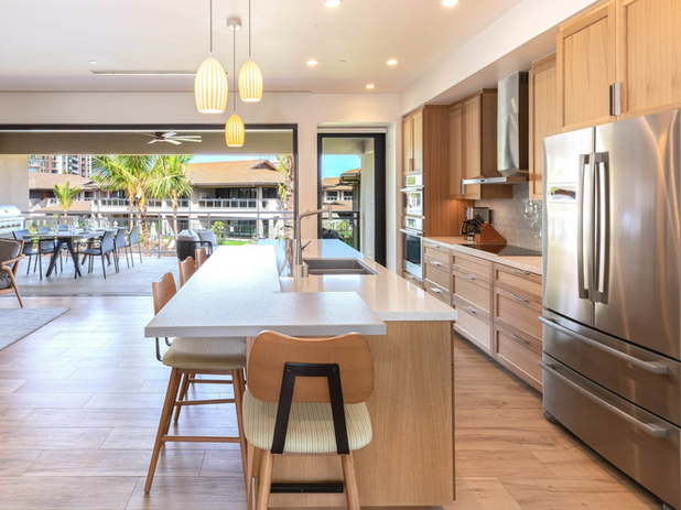 A contemporary kitchen with a large island and high-end appliances, seamlessly connecting to an outdoor dining area.