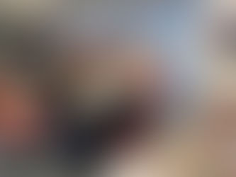 Five women wearing Christmas jumpers standing in a day centre decorated for Christmas