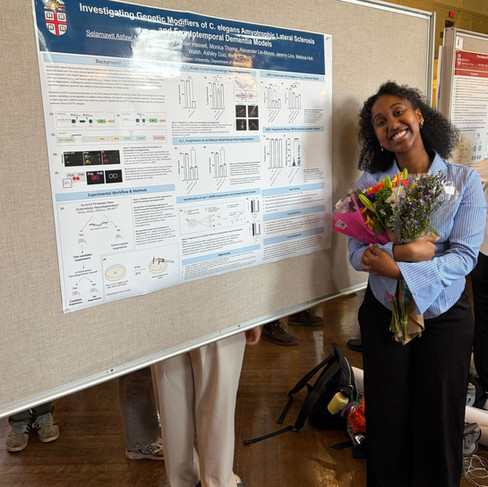 Selam holding a bouquet of flowers by her poster