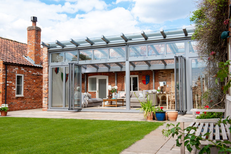 Glazed winter garden extension with folding doors leading to garden.