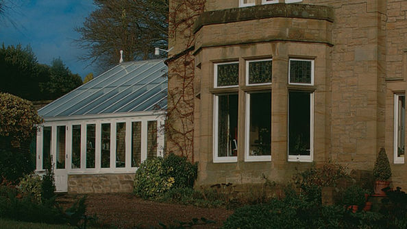 Hardwood conservatory with pitched glass roof on stone-built period house