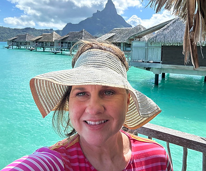 Jodi Wooten overlooking Bora Bora's iconic turquoise lagoon and overwater bungalows.