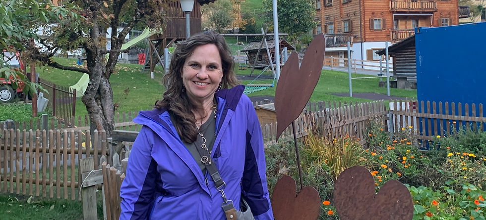Jodi Wooten overlooking a scenic mountain village in Switzerland.