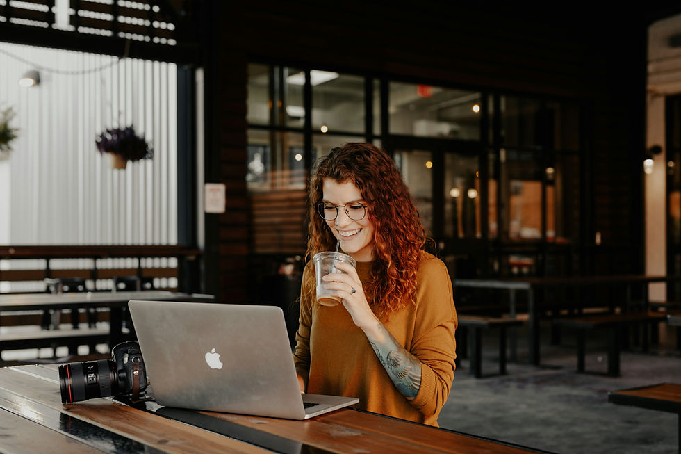 Travel agent working remotely from a coffee shop with laptop and coffee