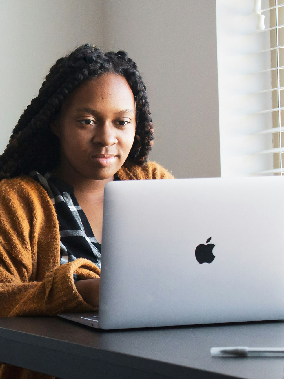 Travel agent planning a client itinerary using notes and laptop at home