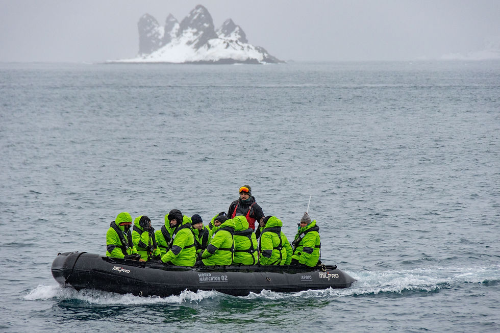 A zodiac cruise ship sails past a glacier in Antarctica.