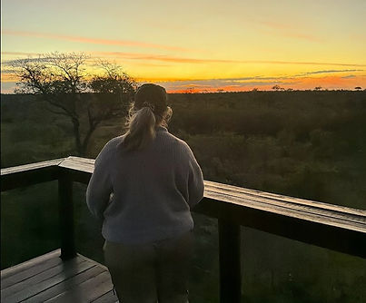 Jennifer Ormesher watching sunrise from the deck of a luxury safari lodge in South Africa.