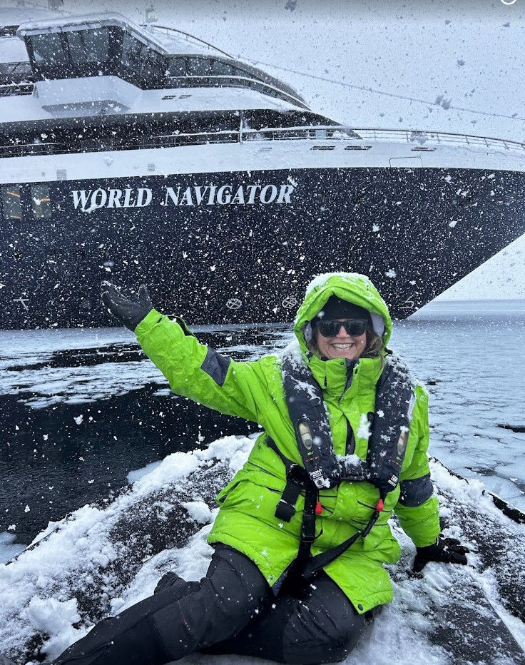 Although it is snowing in Antarctica, Jennifer Ormesher is warm in the parka and boots provided by the expedition cruise line.