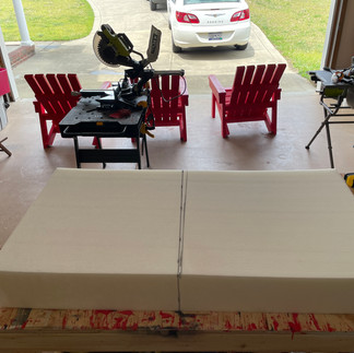 A large piece of 6" thick upholstery foam is marked to length, ready to be cut.