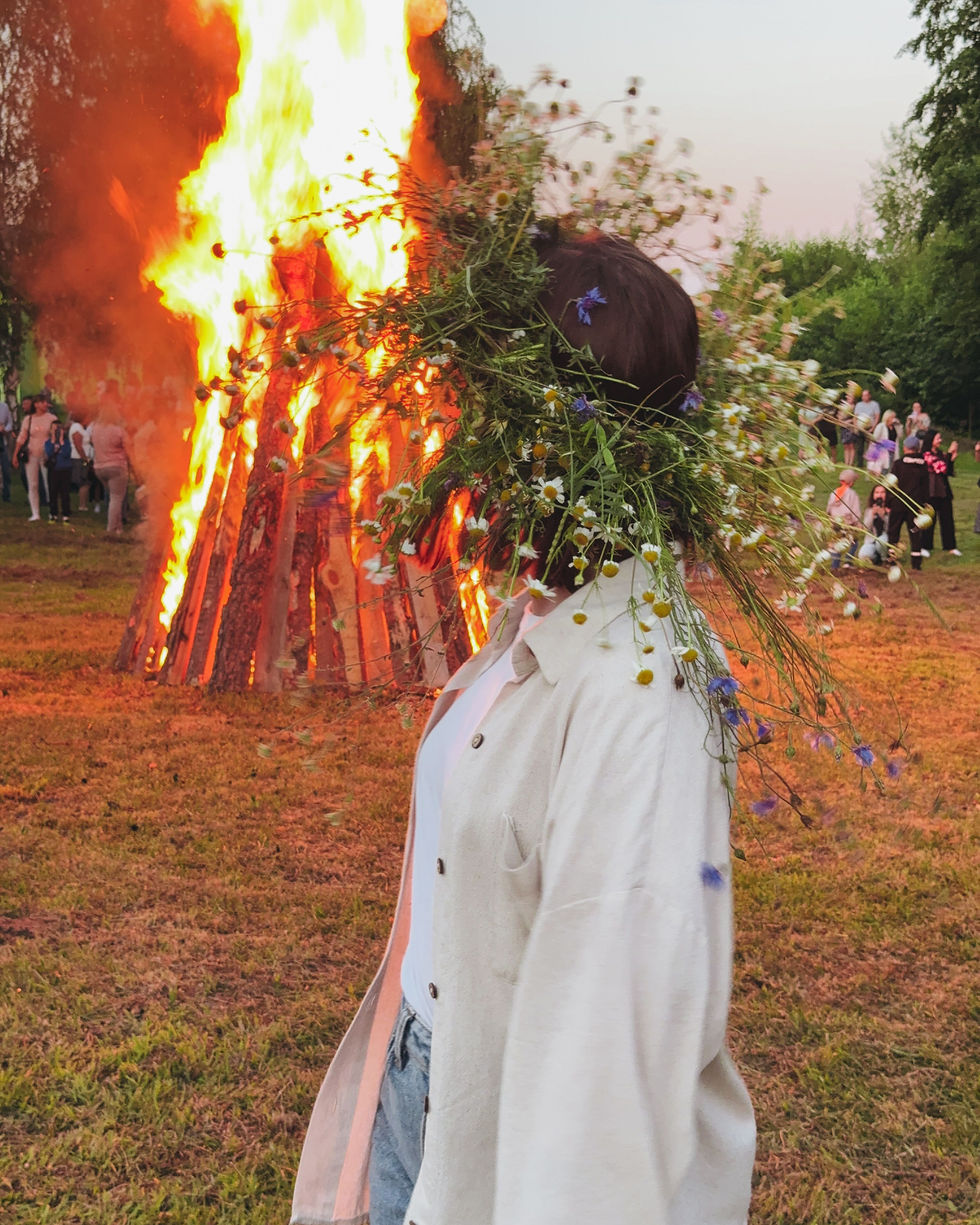 Frau am Feuer mit Blumenkranz auf dem Kopf, Midsommer