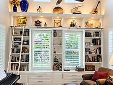 White built-in library wall with a rolling ladder