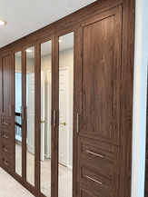 Dark woodgrain built-in wardrobe with mirrored doors
