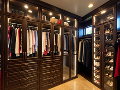 Dark woodgrain walk-in closet with lighted glass doors and drawers