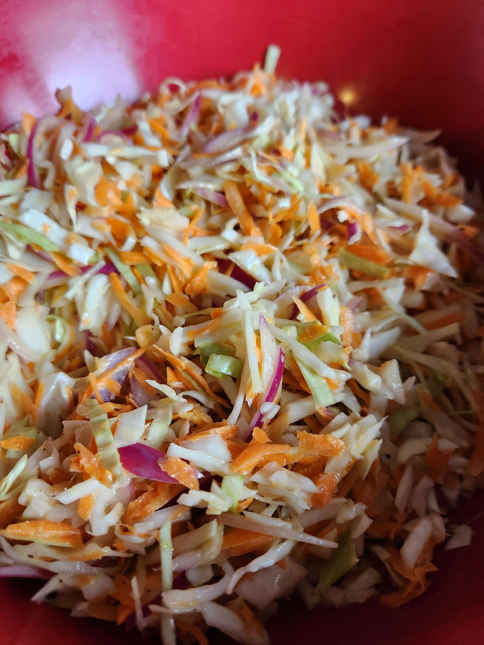 large bowl of shredded carrots, cabbage, red onions