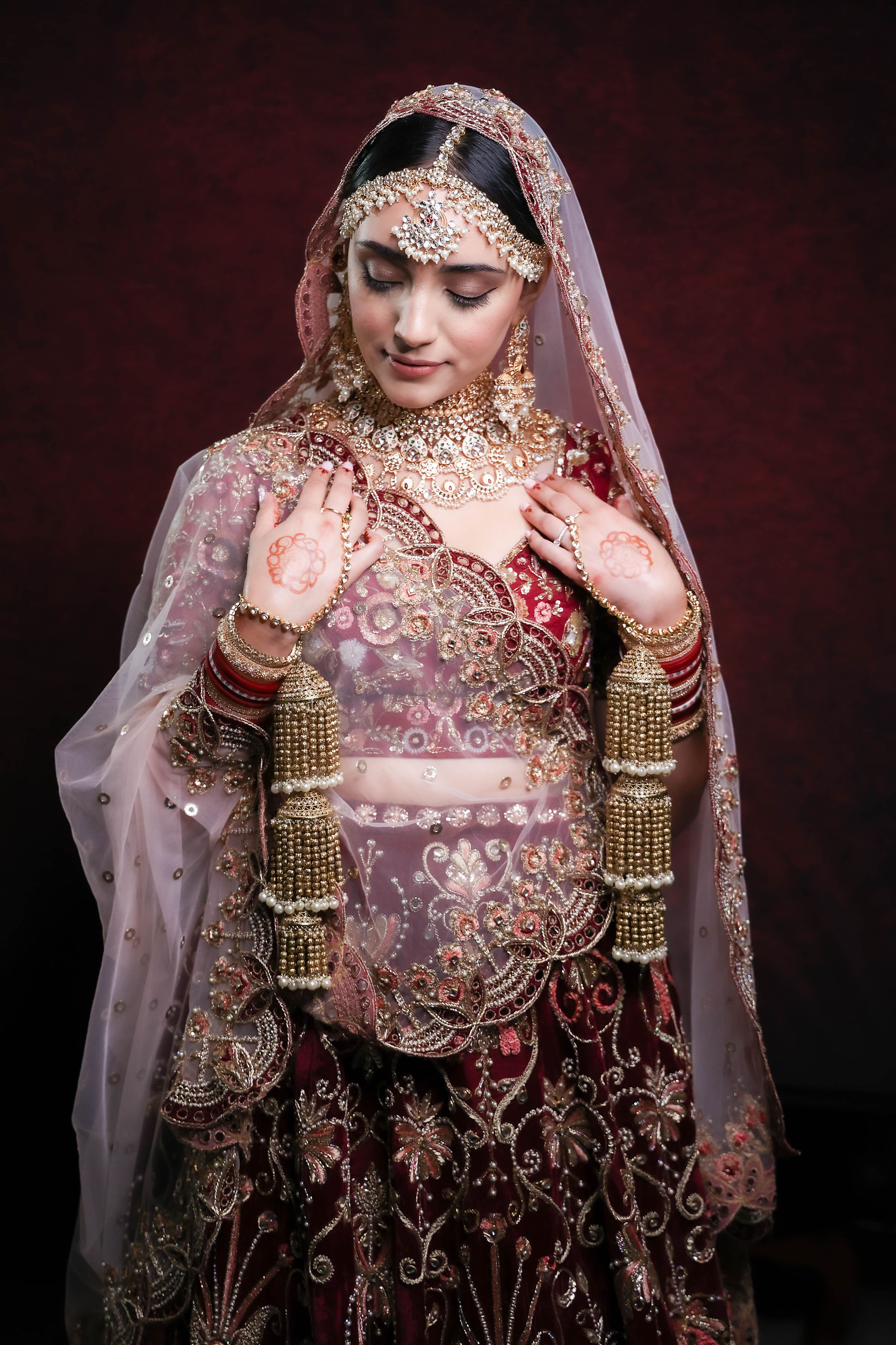 Bride posing infront of Crimson red backdrop