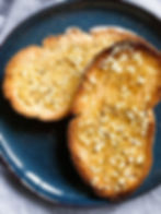 Gluten free garlic bread made with pane di casa style bread on a plate.