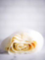 A roll of thin sheets of gluten free filo pastry wrapped in white paper.