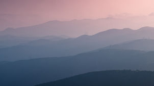 Fog lifting over the mountains, symbolizing the quiet movement of growth.