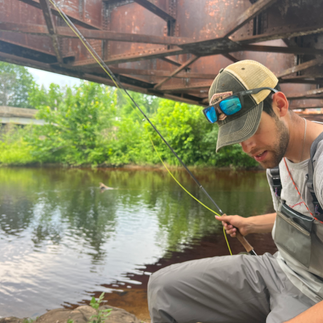 a man fishing under a bridge