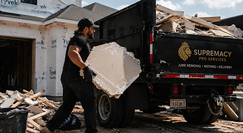 Worker loading renovation debris and construction materials during contractor debris hauling in Indianapolis.