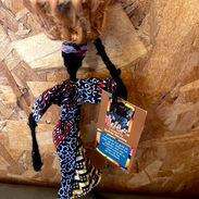A beautifully hand-crafted ornament depicting a Zambian lady in vibrant traditional attire, skillfully balancing a basket of produce on her head, showcasing cultural craftsmanship.