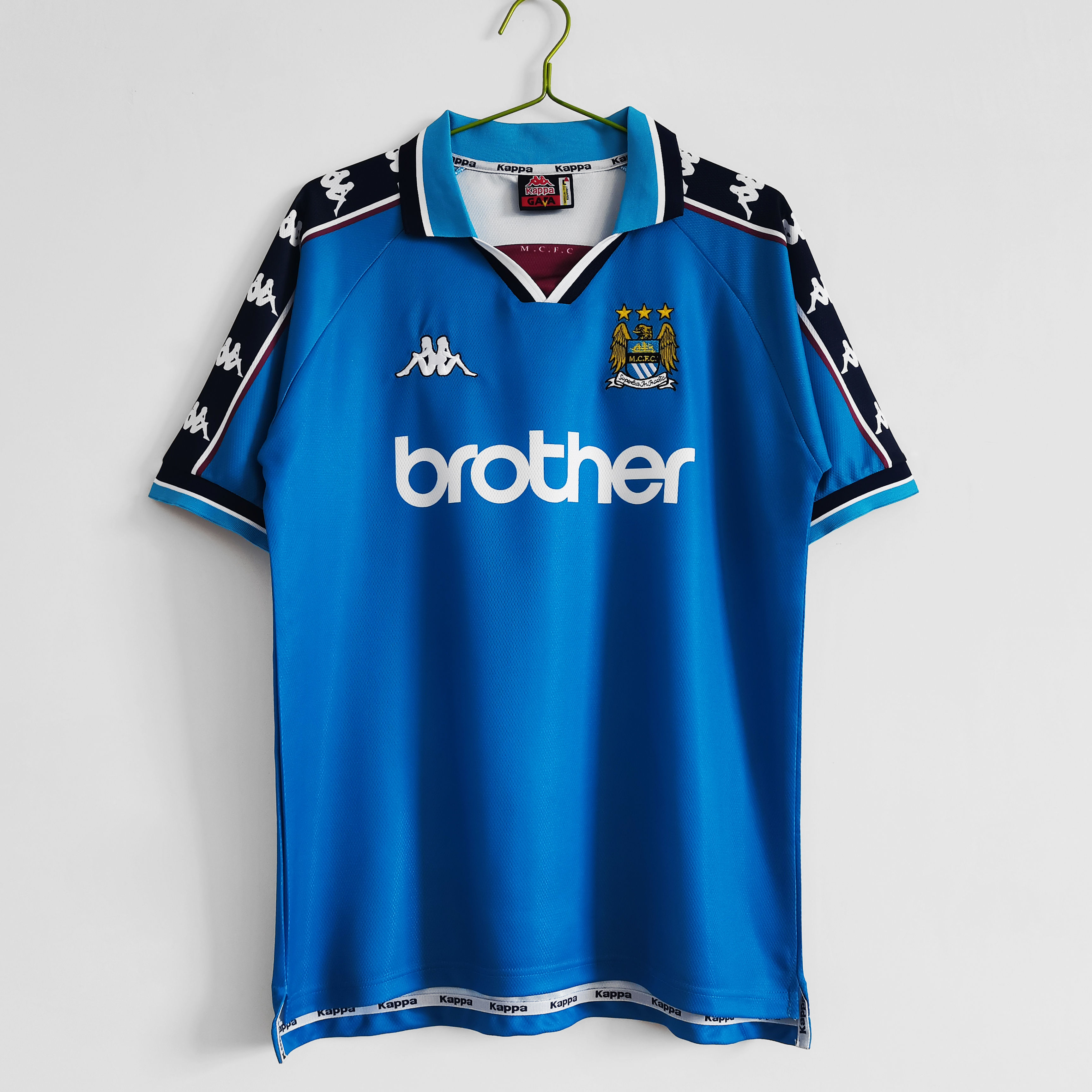 Manchester City retro shirt with Kappa, Brother logo, blue, white accents and Nostalgia Retro Kit.