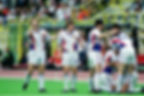 Sevilla players celebrate victory, wearing 1991/1992 SEVILLA HOME RETRO FOOTBALL SHIRT SIVIGLIA, on the pitch.