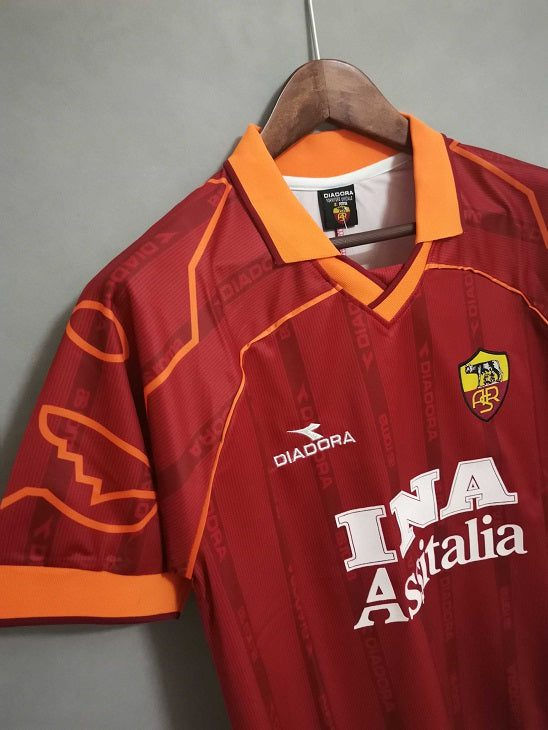 Thumbnail: Close-up of a red AS Roma soccer jersey with visible logos. Nostalgia Retro Kit.