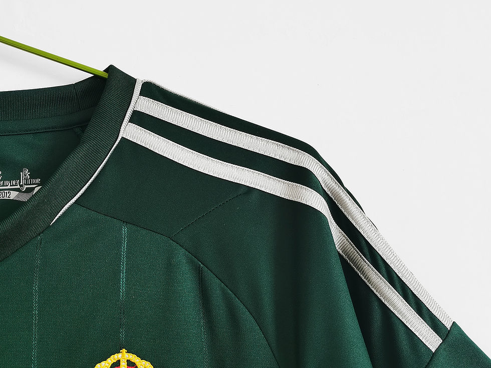 Thumbnail: Green retro football shirt with white stripes on shoulders, hanging on hook. Nostalgia Retro Kit