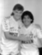 Two soccer players wearing jerseys, Diego Maradona and teammate posing together. Nostalgia Retro Kit