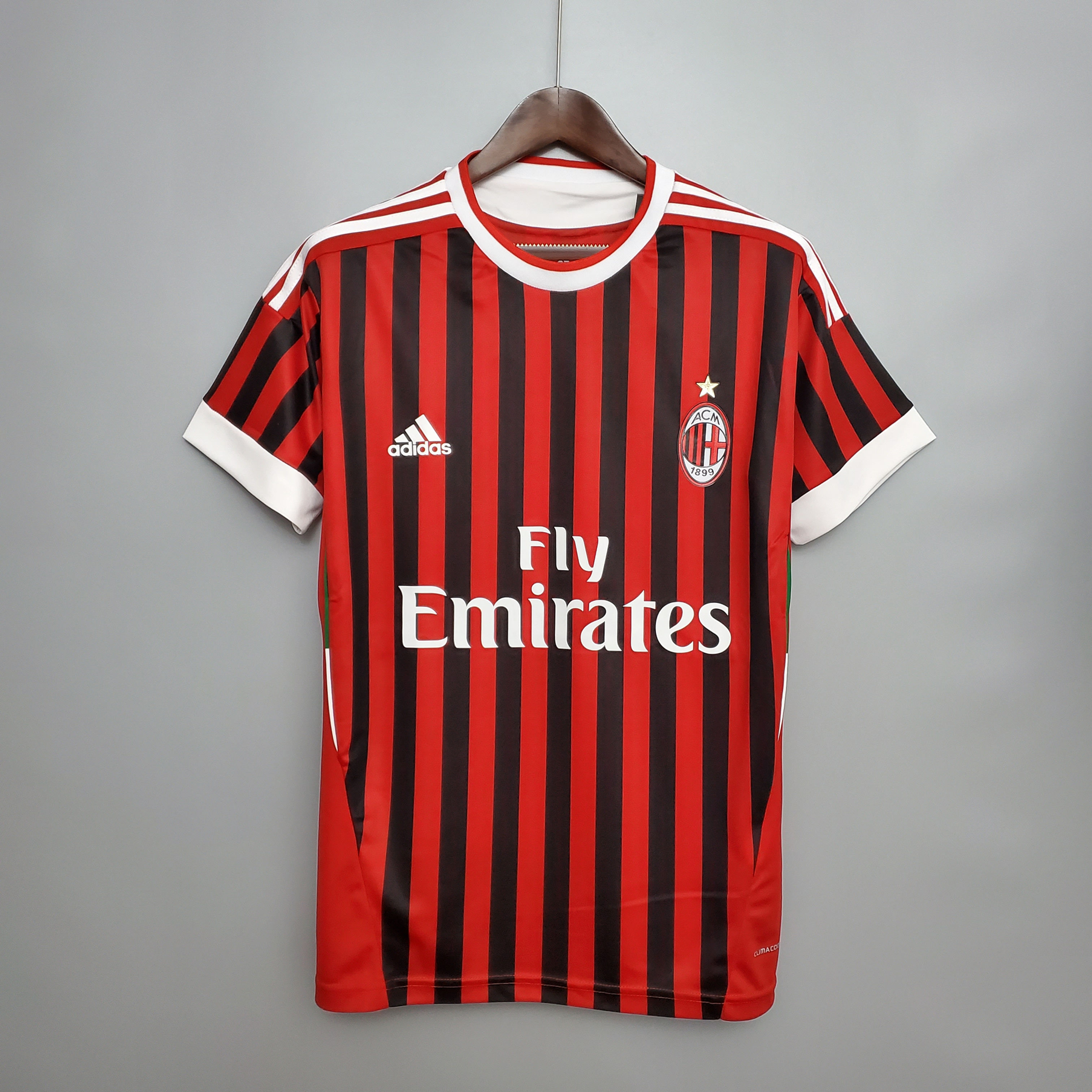 AC Milan jersey with Fly Emirates text. Red and black stripes. Adidas logo. Soccer nostalgia.