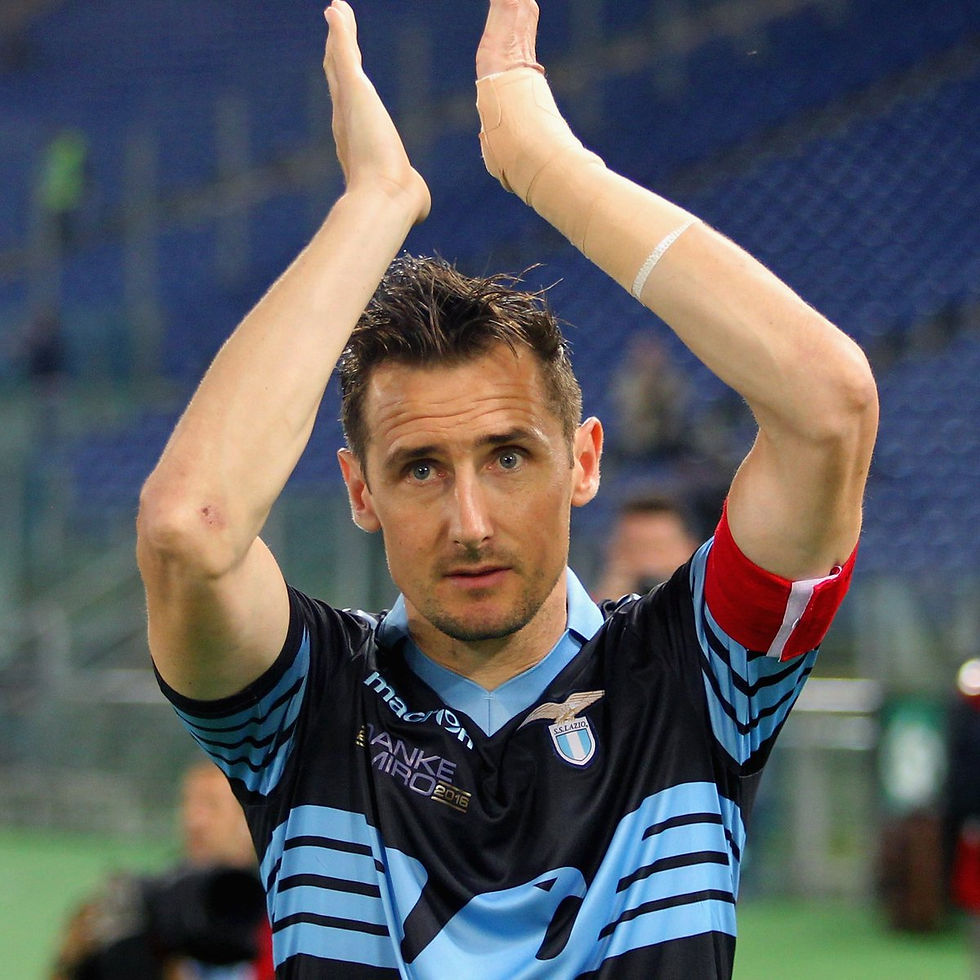 Soccer player applauds with hands up in blue and white jersey on the field