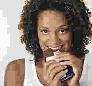 Black woman eating a chocolate candy bar.