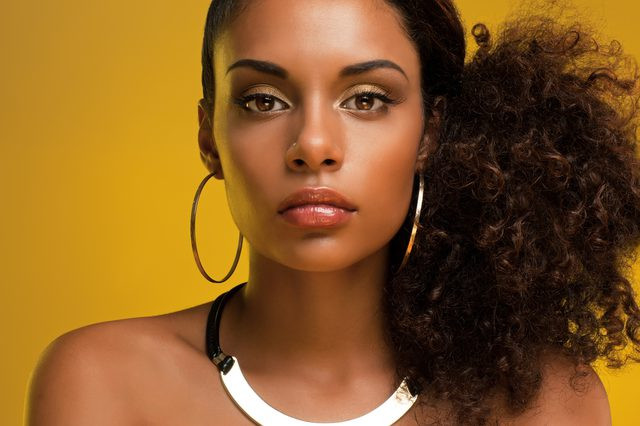 Black healthy woman with a side ponytail.