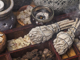 Charcoal-burning resin incense in a burner with white sage.