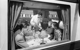 Eye-level view of a grand British stately home with a classic steam train at the nearby station