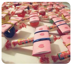 Valentine’s Day candy airplanes made with wrapped sweets and paper details on a white surface