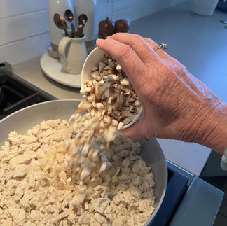 Adding mushrooms and water chestnuts – Fresh mushrooms and diced water chestnuts being poured into browned chicken.