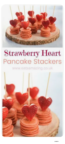 Mini pancake stacks topped with strawberry heart shapes on wooden skewers