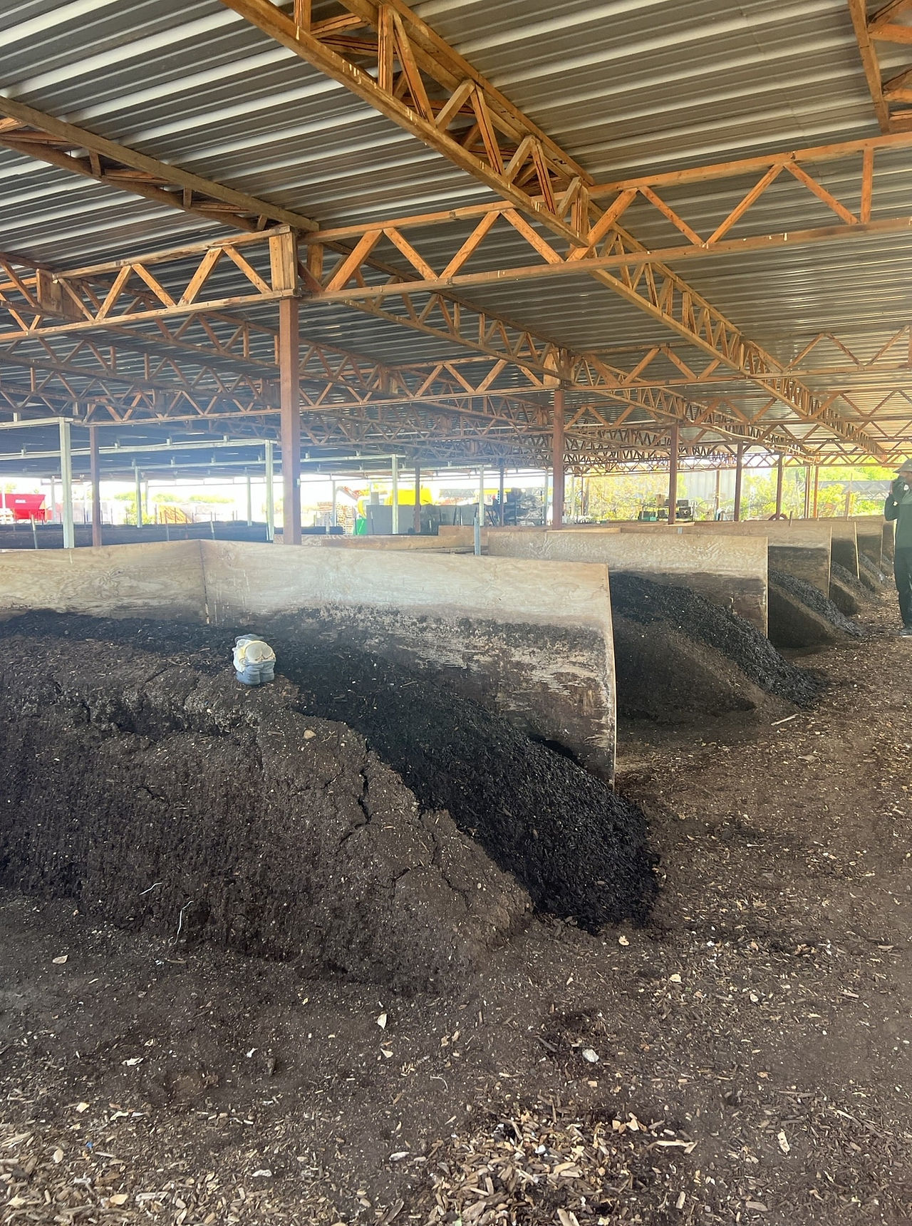 Large compost piles under a covered area at Arizona Worm Farm.