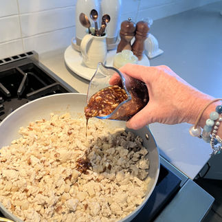 Pouring sauce over chicken mixture – Homemade sauce with hoisin, soy, vinegar, ginger, and garlic being added to the skillet.