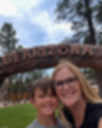Grandma an grandson smiling beneath the Bearizona Wildlife Park entrance arch in Williams, Arizona during a Spring Break road trip.