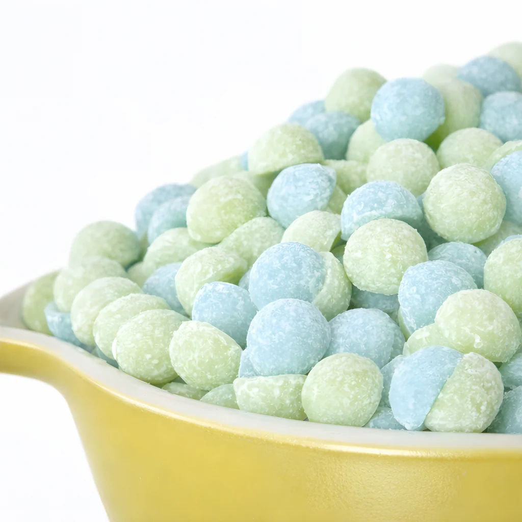 blue-green.webp Blue and green Buttermood Rugged Lotion Drops displayed in a yellow bowl.