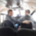 Two pilots in a small plane smiling.