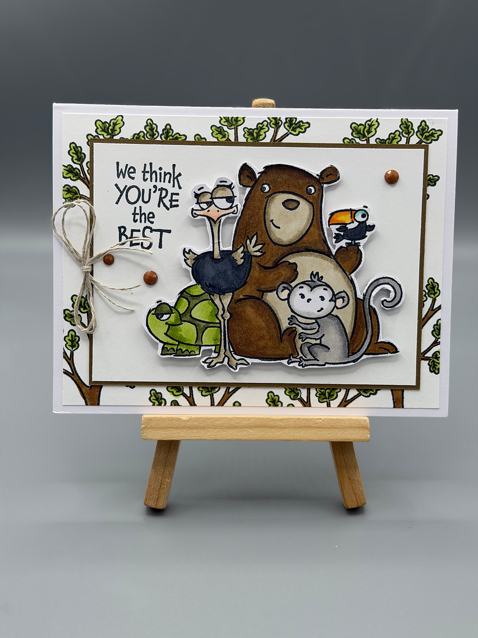 Handmade greeting card featuring illustrated bear, monkey, ostrich, turtle, and toucan with message “We think you’re the best